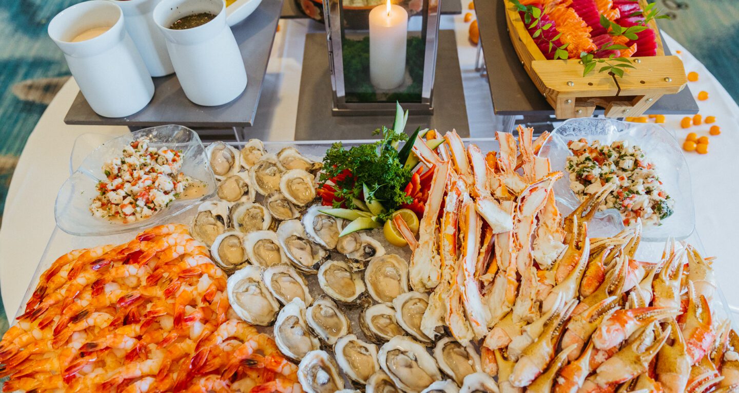 large table filled with shrimp, lobster claws and oysters